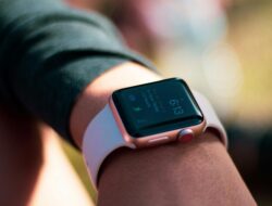 Orang sedang melihat smartwatch di pergelangan tangannya