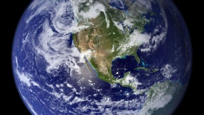 Ilustrasi planet Bumi dilihat dari luar angkasa dengan cahaya matahari yang menyinari permukaan